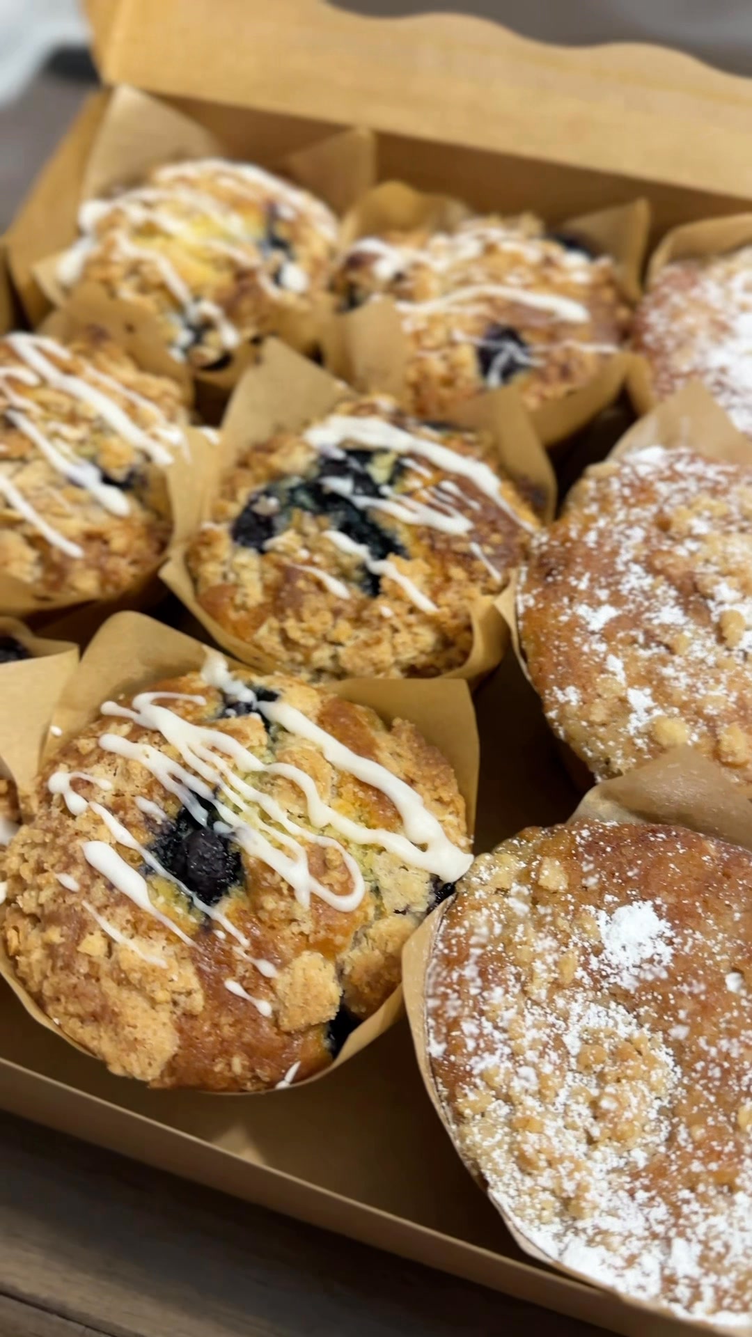Assorted muffins and breakfast pastries in a bakery box